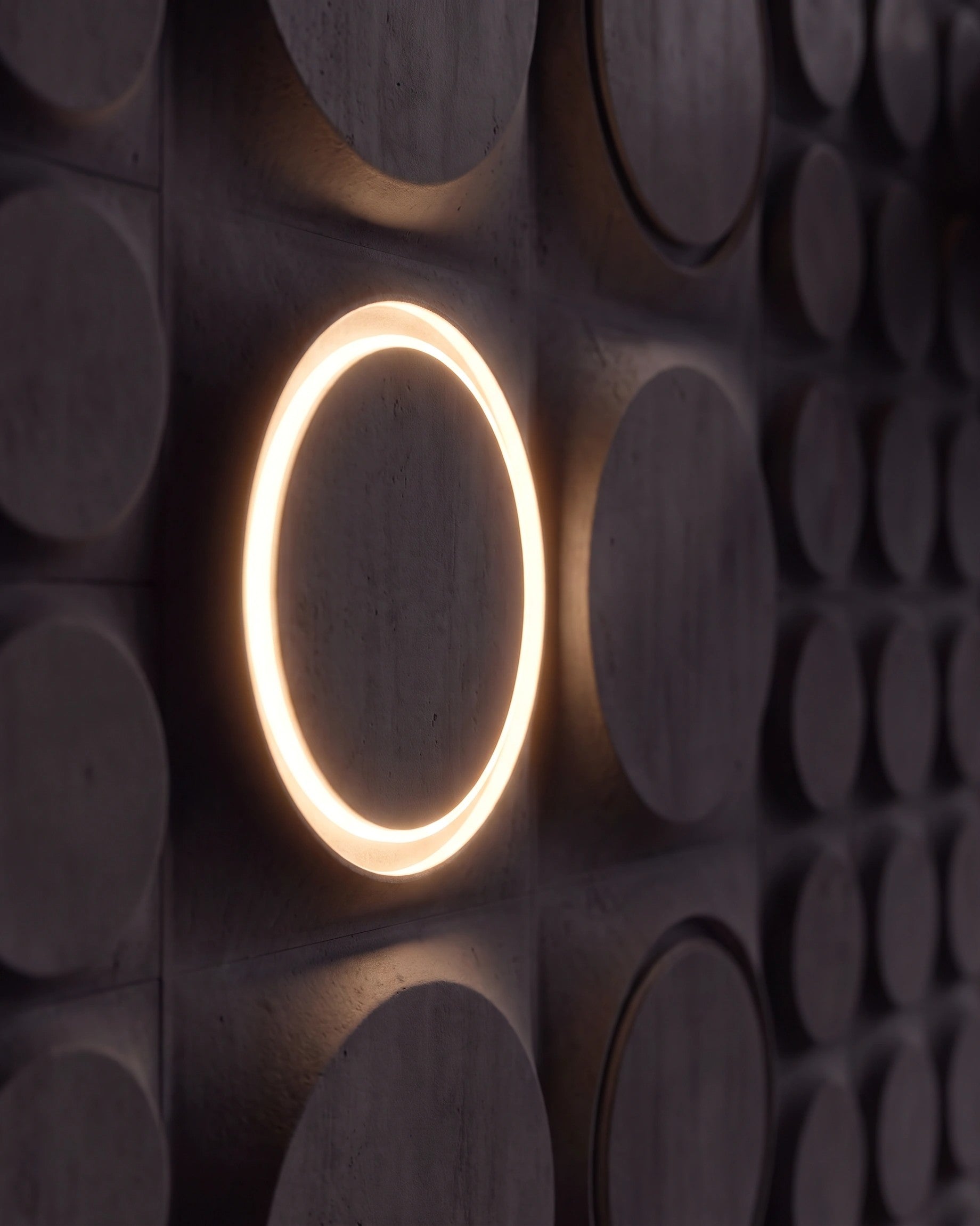 Single COSMIC 0212 LED gypsum 3D wall panel with warm halo ring in side view