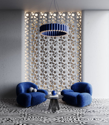 Modern interior featuring Kandes FOAM 3D gypsum wall panels with a sculptural circular pattern, backlit for an elegant ambient glow. The plaster wall panels create a dynamic visual effect, complemented by bold blue lounge chairs, a statement pendant light, and a contemporary black-and-white patterned floor. Ideal for high-end residential and commercial spaces, these decorative panels add texture and depth while maintaining a sleek, minimalist aesthetic.