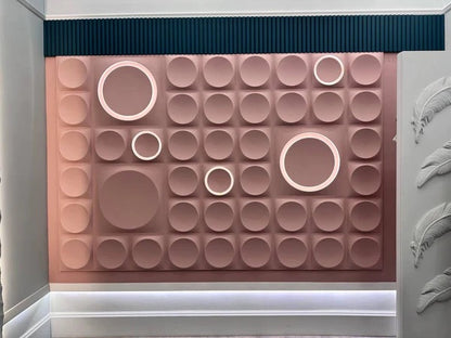 Blush pink geometric gypsum 3D wall panels with circular patterns and integrated LED lighting, creating a striking accent wall in a modern commercial space. These premium plaster 3D panels from Kandes, a Swiss producer of high-quality 3D wall panels, enhance interior design with perfect geometry, indirect lighting, and ambient illumination. Made from all-natural gypsum, A1 non-combustible, and eco-conscious, they provide seamless wall cladding for luxury interiors. Paintable for full customization.