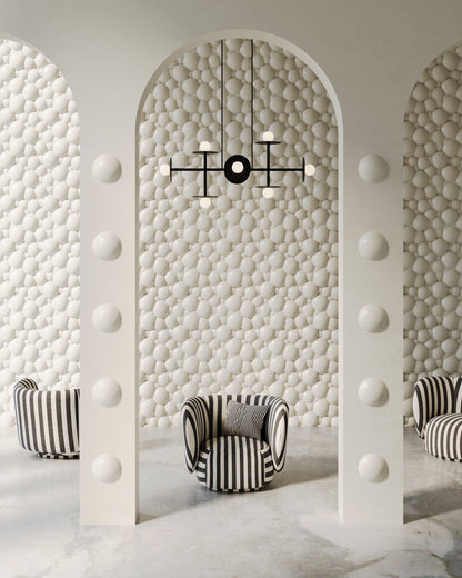 Image features an interior design of a residential or commercial space with backdrop wall and arches made of 3d wall panels from plaster. The interior is modern and luxurious, featuring whimsical modern furniture. 3D wall panels have a high-end porcelain plaster finish effect and bubble or foam-like organic pattern. Interior is in subtle white grey and beige colors. 
Swiss 3D Wall Panel in soft white color depicting foam bubbles
