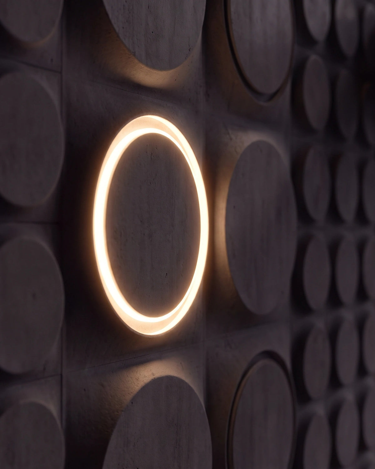 Single COSMIC 0012 LED gypsum 3D wall panel with warm halo ring, side view